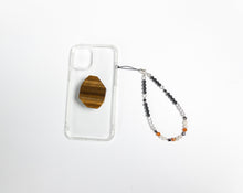 Load image into Gallery viewer, WMC Cancer Zodiac phone charm displayed on a clear phone case with Tigerseye phone grip
