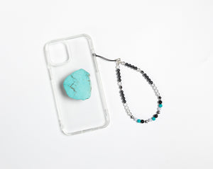 WMC Sagittarius Zodiac phone charm displayed on a clear phone case with Turquoise phone grip